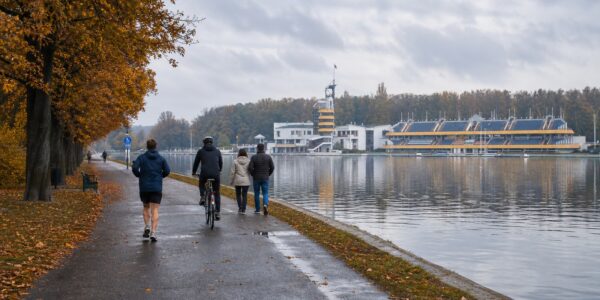Ścieżka wzdłuż brzegu Jeziora Maltańskiego w Poznaniu jesienią, z drzewami w jesiennych kolorach